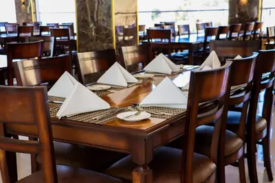 a wooden table with white napkins on it in a restaurant at The RN Hotels in Wadi Musa