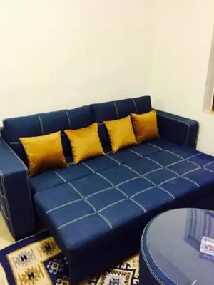 a blue couch with yellow pillows in a living room at The Royal Luxury Lion Patio in Amman