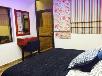 a bedroom with a bed and a desk and a mirror at The Royal Luxury Tiger Patio in Amman