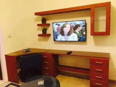 a room with a desk with a tv on a wall at The Royal Luxury Tiger Patio in Amman