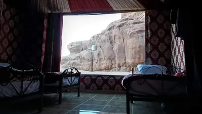 a room with a view of a mountain through a window at Why not camp in Wadi Rum