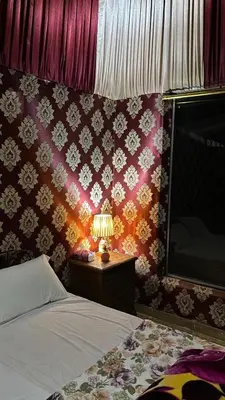 a bedroom with a bed and a table with a lamp at Why not camp in Wadi Rum