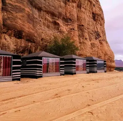 a row of black and white buildings in the desert at Why not camp in Wadi Rum