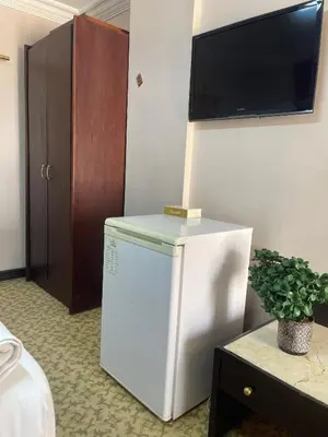 a white refrigerator in a room with a tv on the wall at Dweik Rooftop in Aqaba