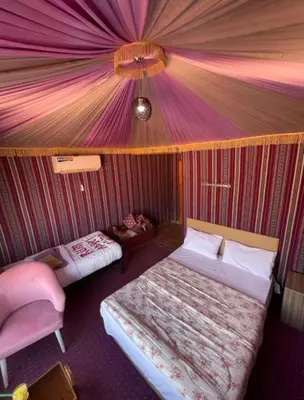 a room with two beds and a tent at Wadi Rum Khalifa Camp in Wadi Rum