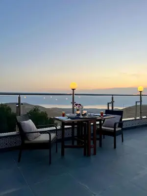 a table and chairs on a balcony with a view at Golden rays chalet in Madaba