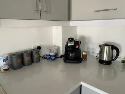 a kitchen counter with a coffee maker and cups on it at Golden rays chalet in Madaba