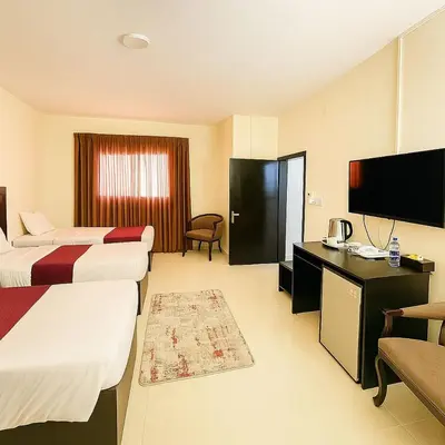 a hotel room with two beds and a flat screen tv at Plaza View Hostel in Taiyiba
