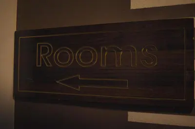a sign with an arrow pointing to rooms with an arrow at Plaza View Hostel in Taiyiba