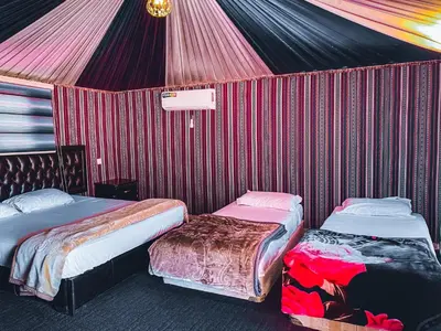two beds in a room with a tent at Rum Serena Camp in Wadi Rum