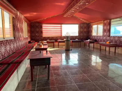 a large room with benches and tables in it at Rum Serena Camp in Wadi Rum