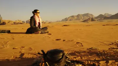 a person sitting on the ground in the desert at Wadi rum safari 1 camp in Wadi Rum