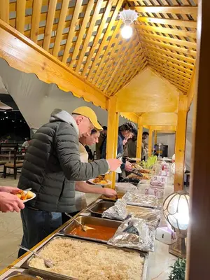 a group of people preparing food at a buffet at Arjowana Luxury Camp & Bubbles Hotel in Wadi Rum