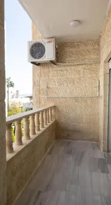 a balcony with a microwave on a wall at Hanan Residence 01 - 3BR, Der Ghbar 165m2 in Amman