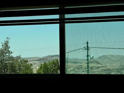 a window with a view of a mountain view at Petra Gold Inn Apartments in Wadi Musa