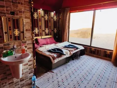 a bedroom with a bed and a sink and a window at Nafa Rum Camp in Wadi Rum