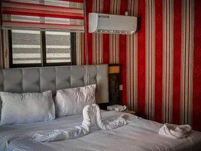 a bed with a comforter with a stuffed animal on it at Tower Rum Camb in Wadi Rum