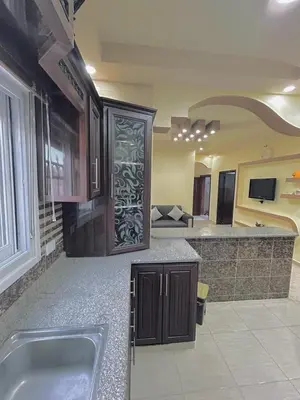 a large kitchen with a sink and a living room at Leen Guest House in Wadi Musa
