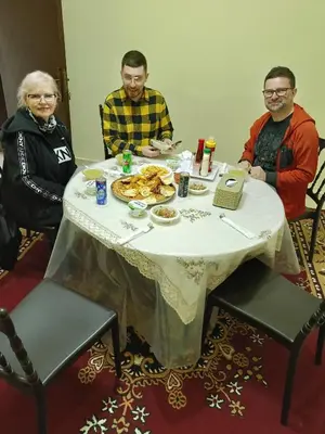 a group of people sitting around a table with food at Leen Guest House in Wadi Musa
