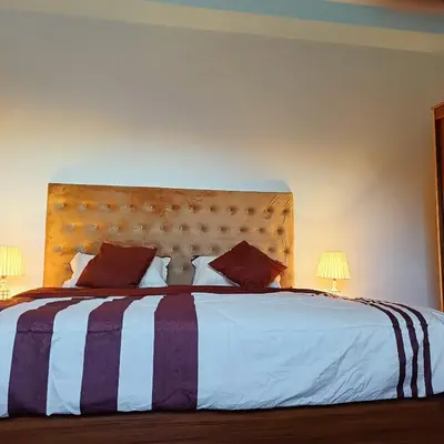 a bedroom with a large bed with two lamps at Leen Guest House in Wadi Musa