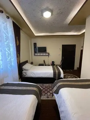 a hotel room with two beds and a television at Ad Deir Guesthouse in Wadi Musa