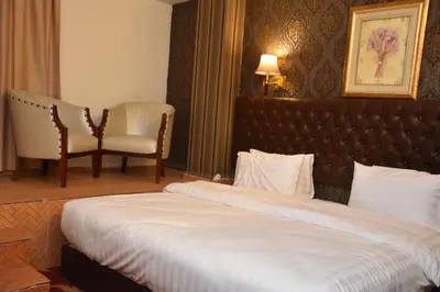 a hotel room with a bed and a chair at Madison Hotel in Amman