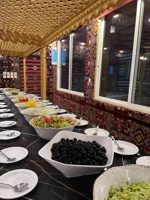 a buffet line of bowls of food on a table at Shaheen Camp Wadi rum in Wadi Rum