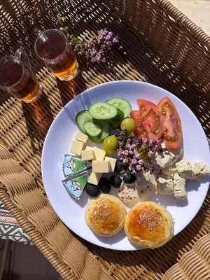 a plate of food with cheese and vegetables on a table at Shaheen Camp Wadi rum in Wadi Rum