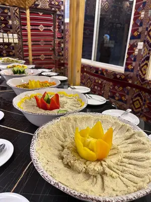 a table topped with plates and bowls of food at Shaheen Camp Wadi rum in Wadi Rum
