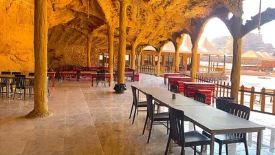 a pavilion with tables and chairs in a building at Youssef camp Wadi Rum in Wadi Rum