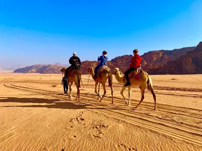 three people riding on horses in the desert at Youssef camp Wadi Rum in Wadi Rum