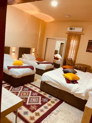 a hotel room with three beds and a mirror at Petra fort hotel in Wadi Musa