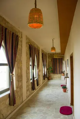 a hallway in a house with windows and a rug at Petra fort hotel in Wadi Musa