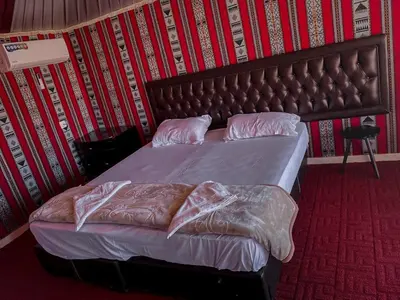 a bedroom with a bed with a leather headboard at Scoop Rum in Wadi Rum