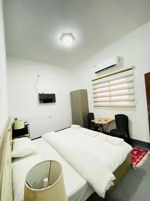 a bedroom with a large white bed and a desk at Grandpa House in Wadi Musa