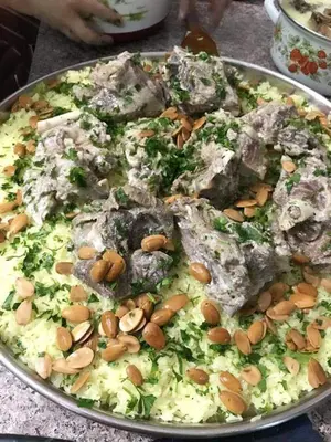 a pizza with almonds on a pan on a table at Grandpa House in Wadi Musa