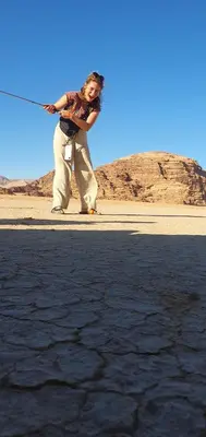 a woman standing on a beach holding a fishing pole at Bedouin experiences in Aqaba