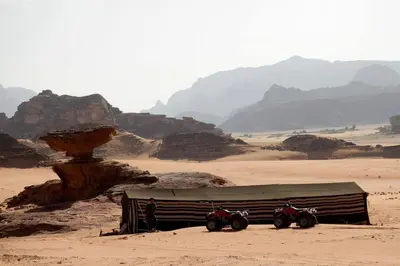 two motorcycles parked next to a building in the desert at Bedouin experiences in Aqaba