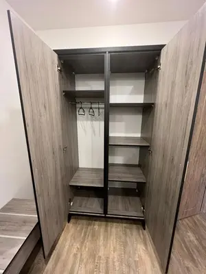 a walk in closet with wooden walls and shelves at Caprios motel in Al Qasţal