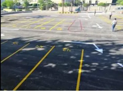 a parking lot with a blue arrow painted on it at Caprios motel in Al Qasţal