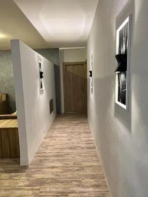 a hallway leading to a room with a door at Caprios motel in Al Qasţal