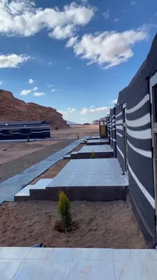 a concrete retaining wall with a fence in the desert at Wadi Rum Cream in Wadi Rum