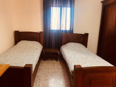 two beds in a small room with a window at Madaba Hills Apt in Madaba