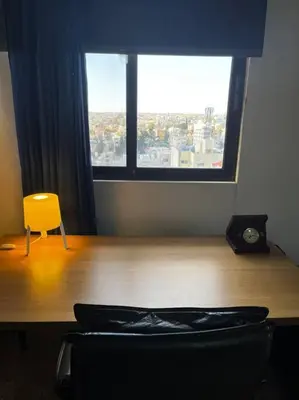 a room with a table and a yellow chair and a window at Madaba Hills Apt in Madaba
