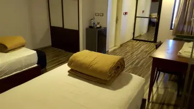 a hotel room with a bed with a yellow pillow on it at Al Namteh Lodge in ‘Ābil
