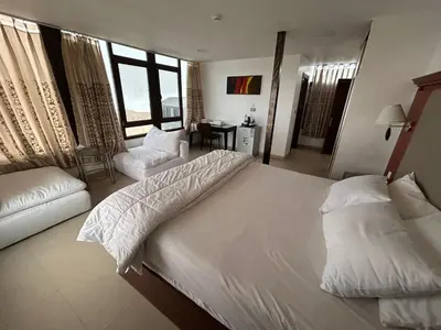a bedroom with a large white bed and a couch at Al Namteh Lodge in ‘Ābil