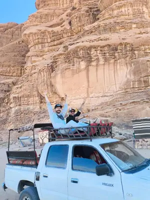 a man and a woman sitting on the back of a truck at Wadi rum view camp in Wadi Rum