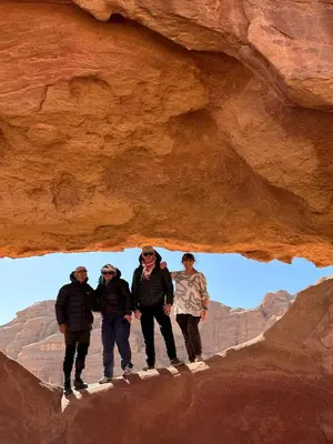 a group of people standing in a cave at Wadi rum view camp in Wadi Rum