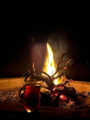 a fire in a fire pit with a drink in front of it at Wadi rum view camp in Wadi Rum