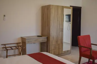 a bedroom with a bed and a desk and a mirror at Twilight Hotel Petra in Wadi Musa
